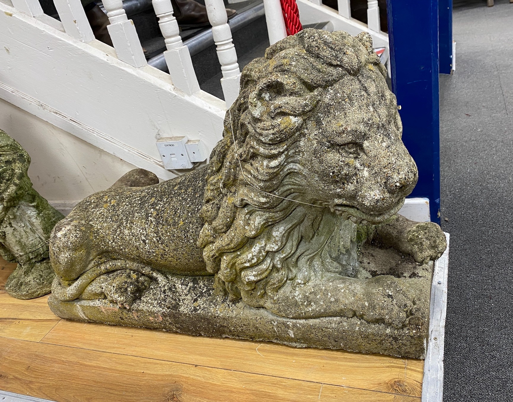 A large reconstituted stone recumbent lion garden ornament, length 91cm, depth 33cm, height 60cm